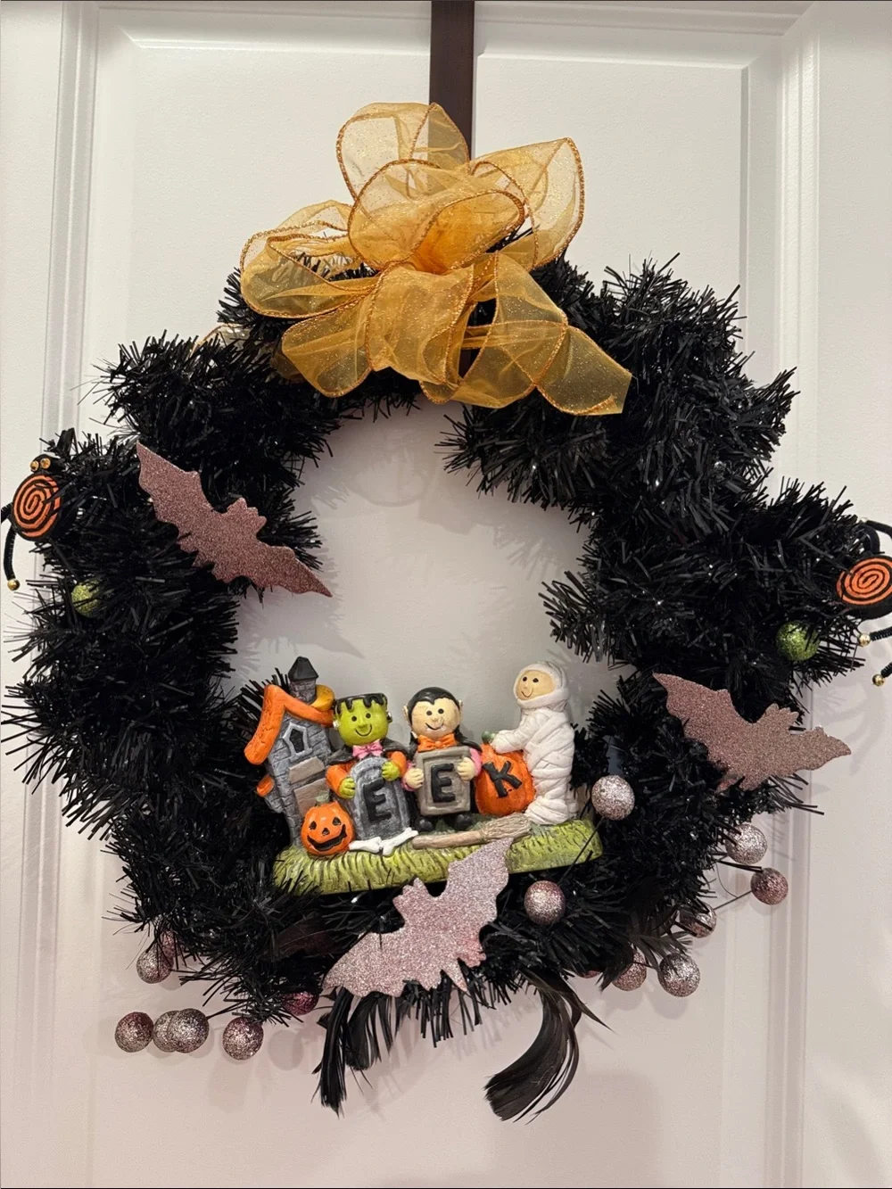 Black Halloween Wreath with Gold Bow and Trick-or-Treat Figurines